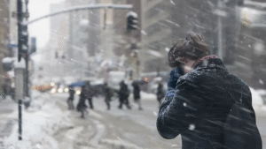  image of a young woman walking through a snow storm